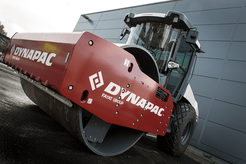 Close-up view of a Dynapac road roller machine with a red front and branding visible. Binar Solutions helped Dynapac improve their production flow using Takt, Andon, and Visualization.